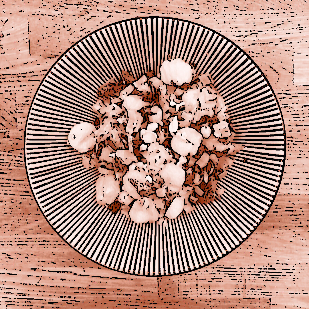 Ein Teller mit Gnocchi-Auflauf mit Mangold, Kichererbsen, Oliven, getrockneten Tomaten und gehackten Cashewkernen, serviert auf einem blau-weiß gestreiften Teller auf einem Holztisch.