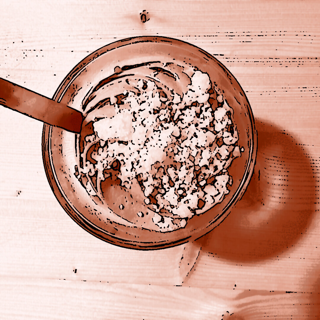 Schokomousse mit Crumble in einer Glasschüssel, serviert mit einem Löffel, auf einem Holztisch in der Lizumer Hütte.